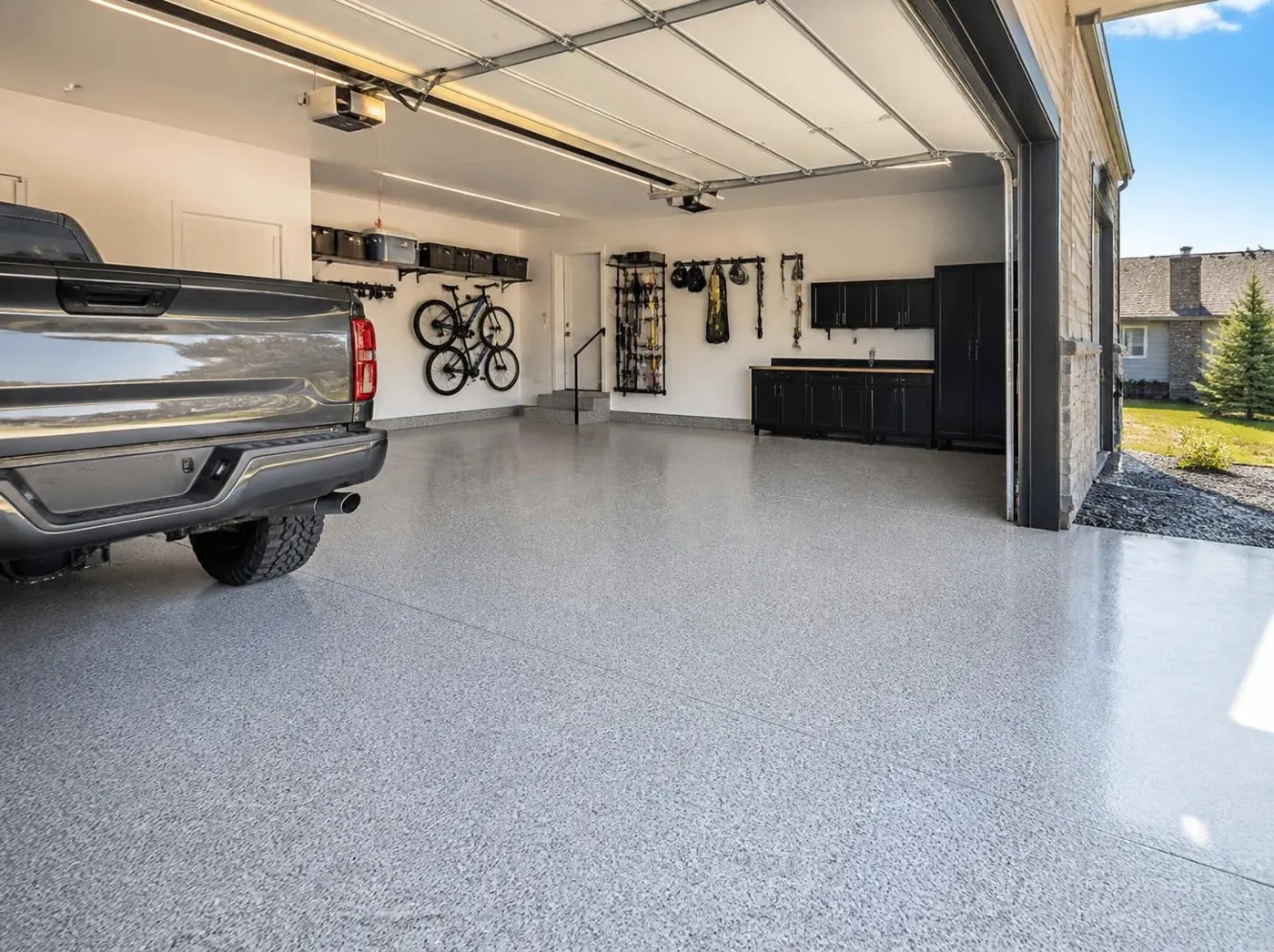 Three-car garage with a light gray polyaspartic flake floor